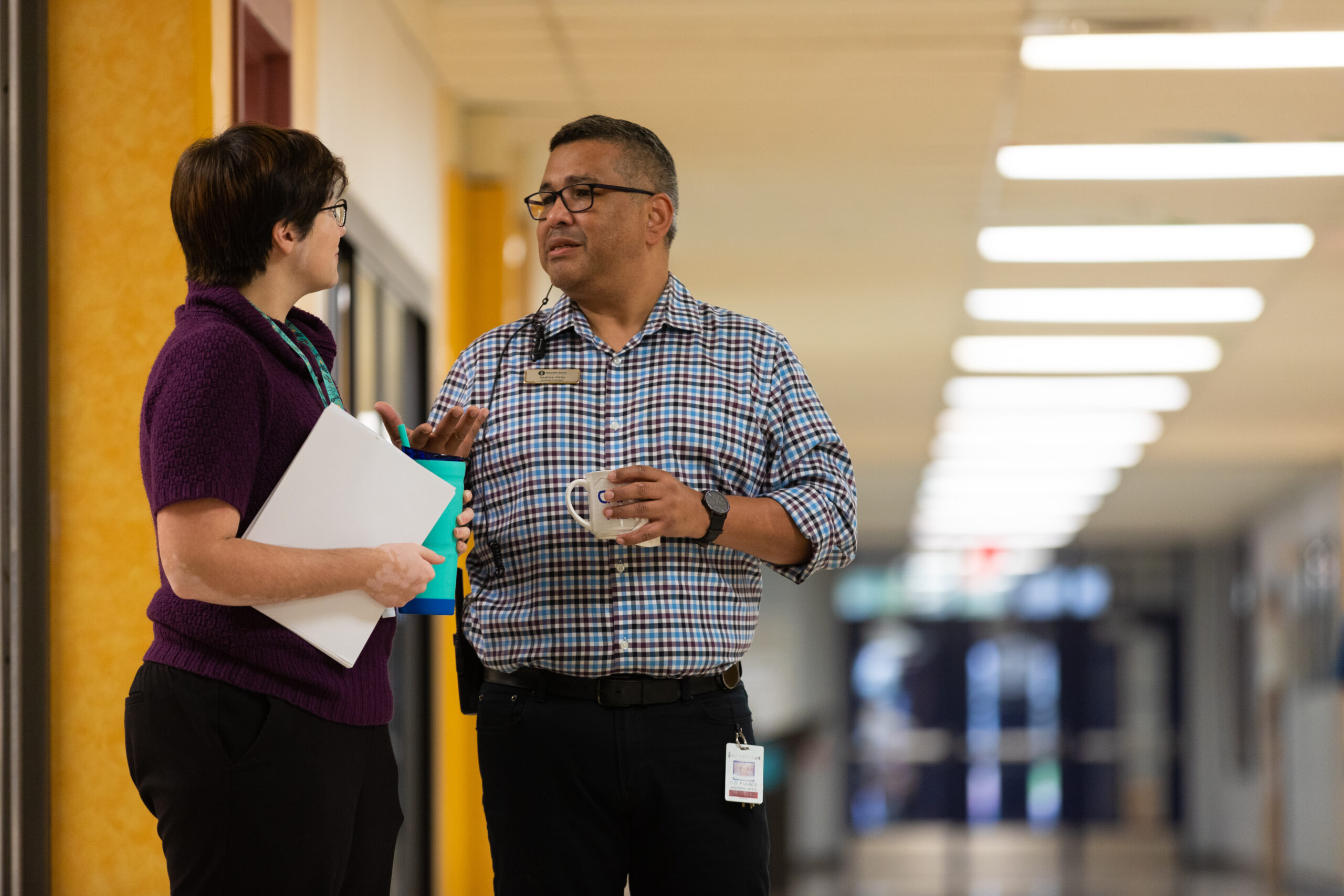 two teachers speaking in a hallway